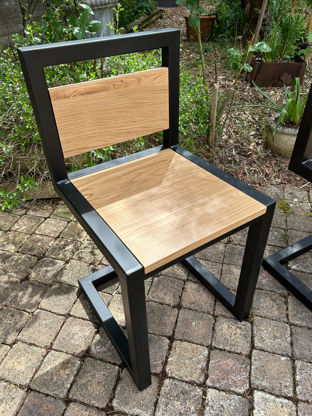 Chaises, tabourets et bancs industriels sur mesure fabriqués en atelier, avec assise en chêne massif vernis satiné, mobilier artisanal en bois et métal.